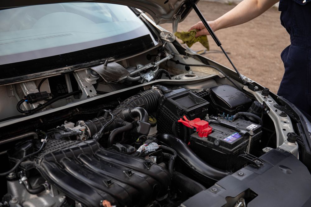 Mechanic inspecting a car's engine bay during routine maintenance